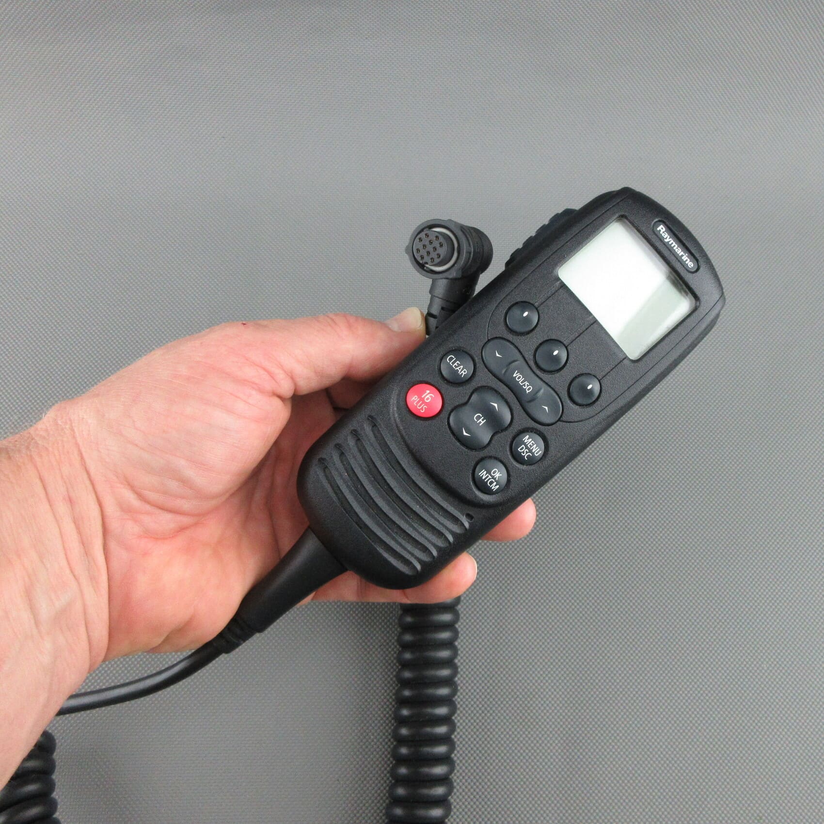 Vista frontale della cornetta VHF Raymarine® Ray260 A80197 rigenerata, tenuta in mano, con dettaglio del connettore.